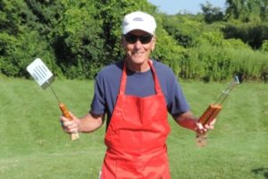 The chef at our 2018 summer picnic holding out his hands in welcome