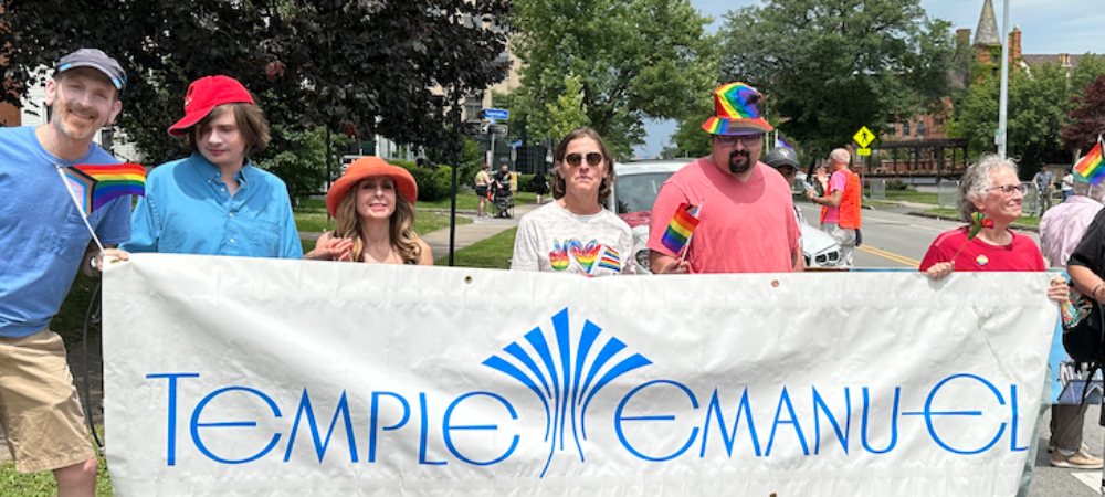 Temple Emanu-El Members marching with a large banner in Rochester's Pride Parade